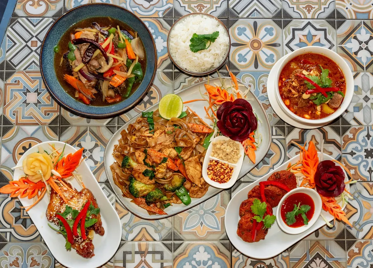 Overhead view of plated restaurant dishes on a tiled table