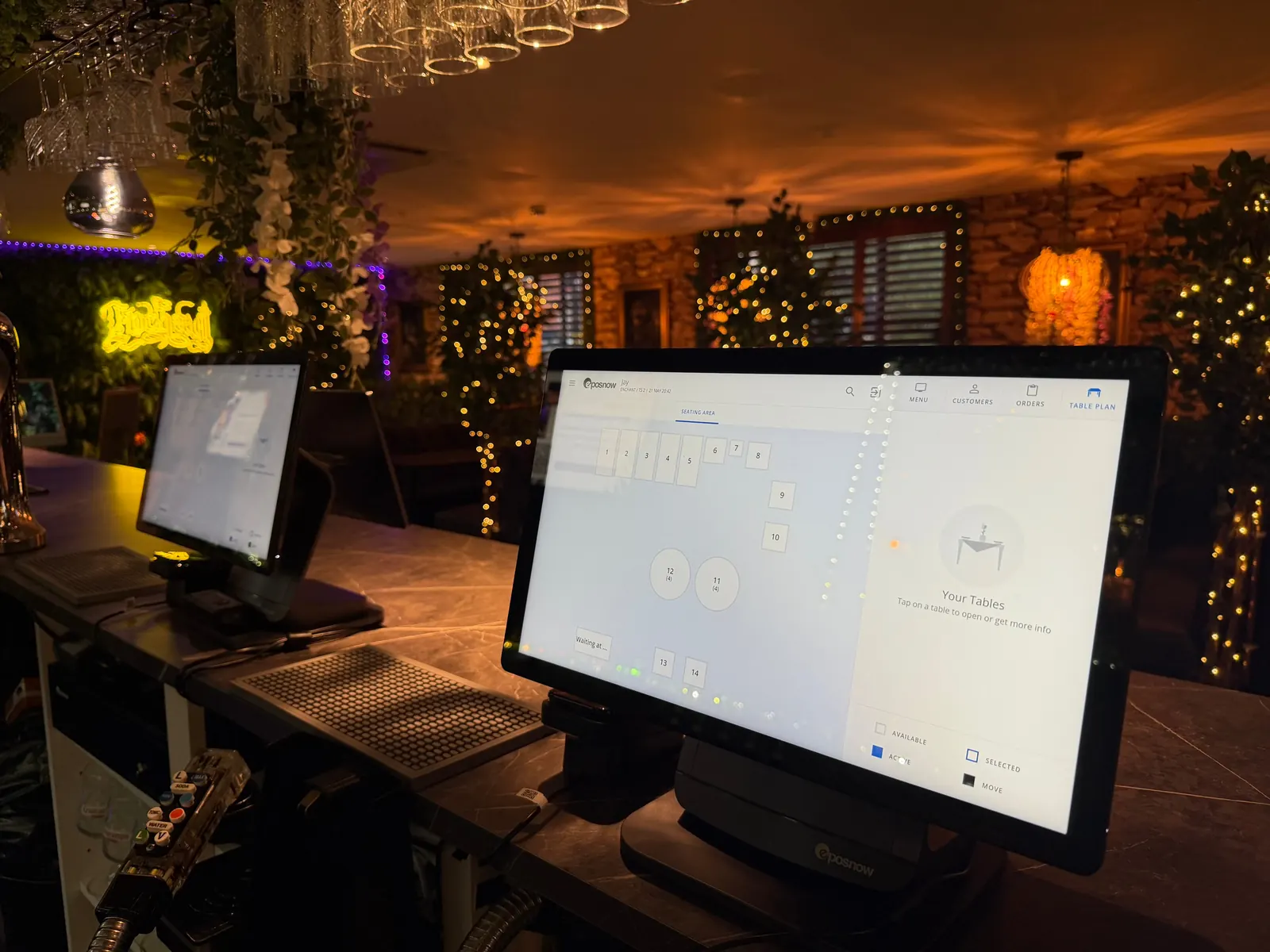 Epos Now touchscreen terminal on a bar counter in a dimly lit venue