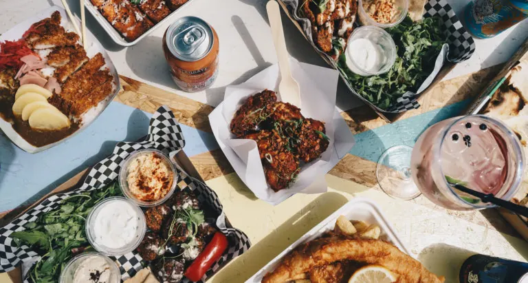 Overhead view of a table of burgers, ribs and sides with drinks