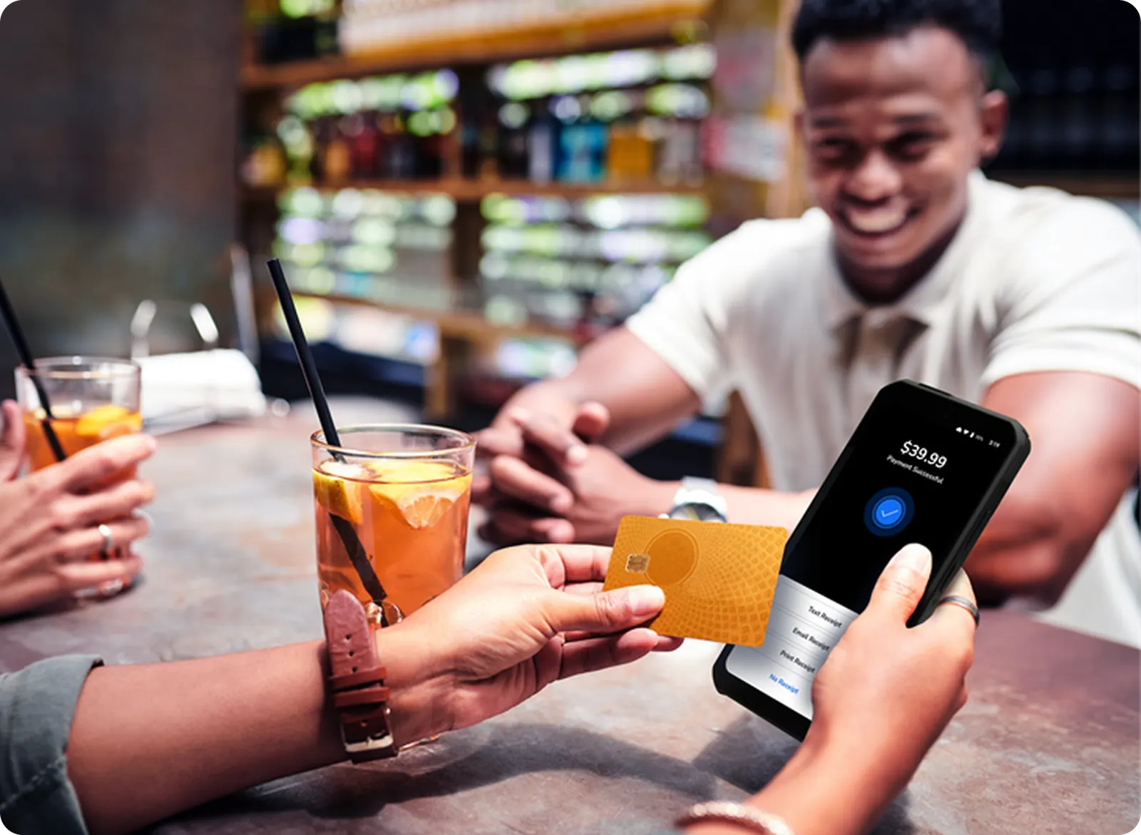 Guest tapping a card on a handheld terminal at a bar