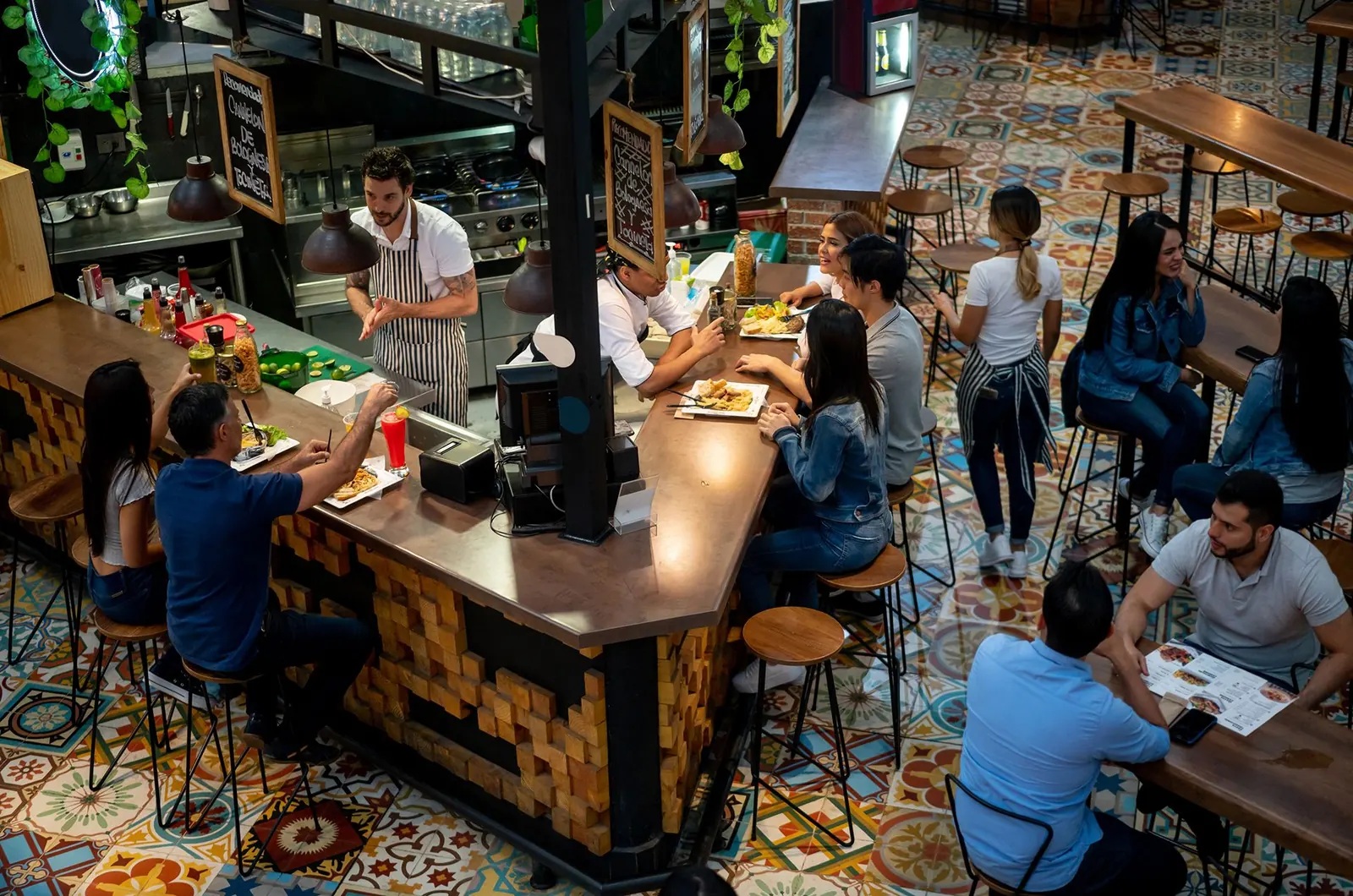 Aerial view of a busy bar counter with staff and customers