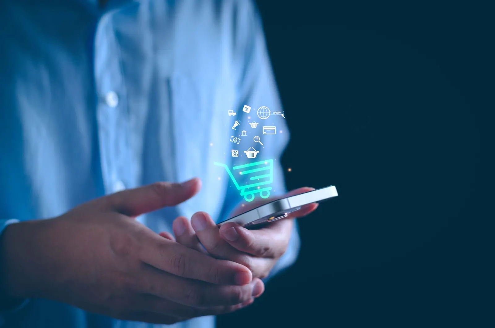 Hands holding a phone with a shopping cart icon glowing above it
