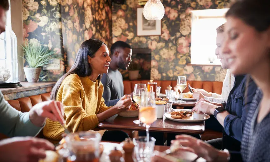 Group of diners seated around a restaurant table